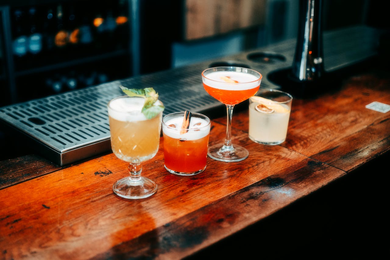 A vibrant selection of cocktails on a wooden bar, perfect for nightlife and parties.